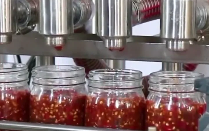 Jars of food product being filled on a production machine